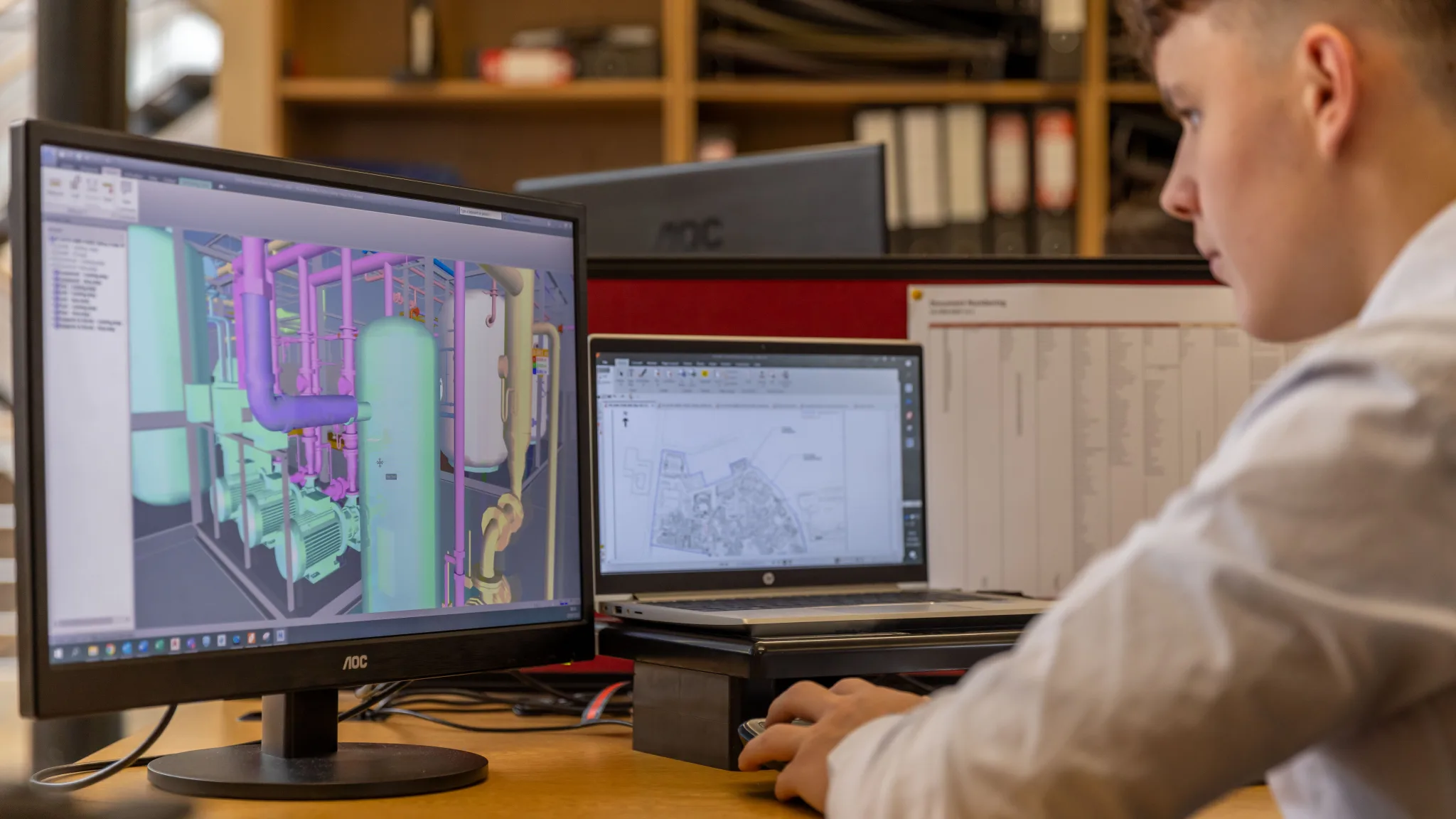 Engenheiro trabalhando em modelo 3D de tubulação em estação de trabalho CAD